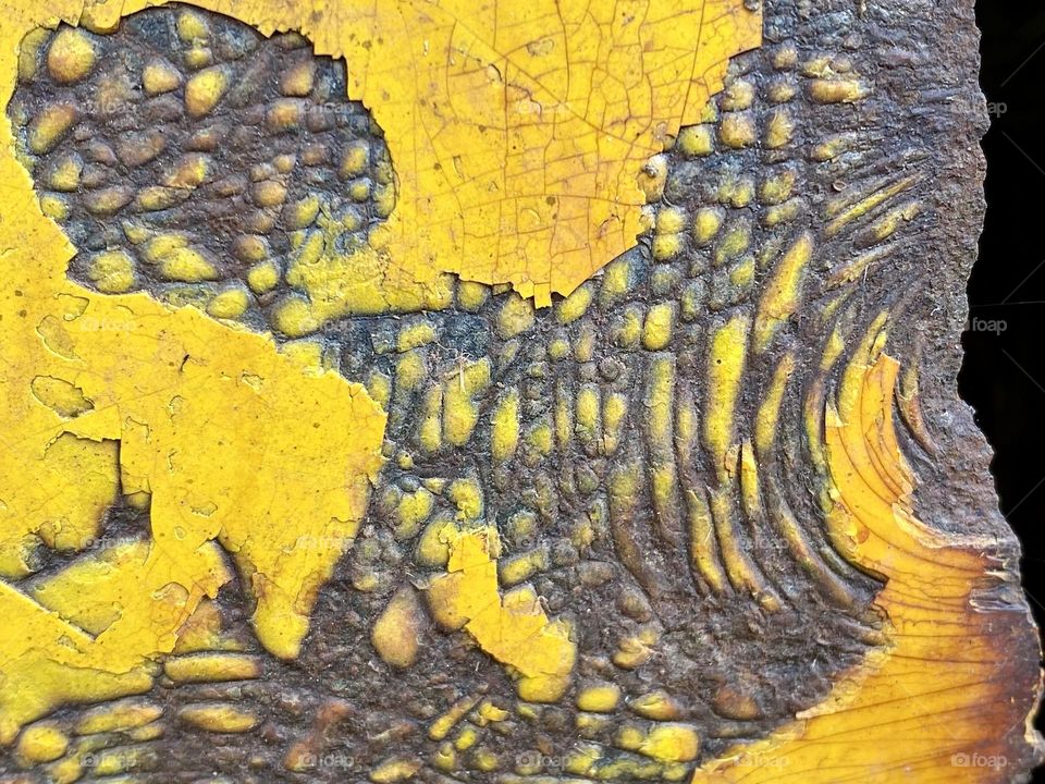 Rust and scratches on a piece of yellow painted metal