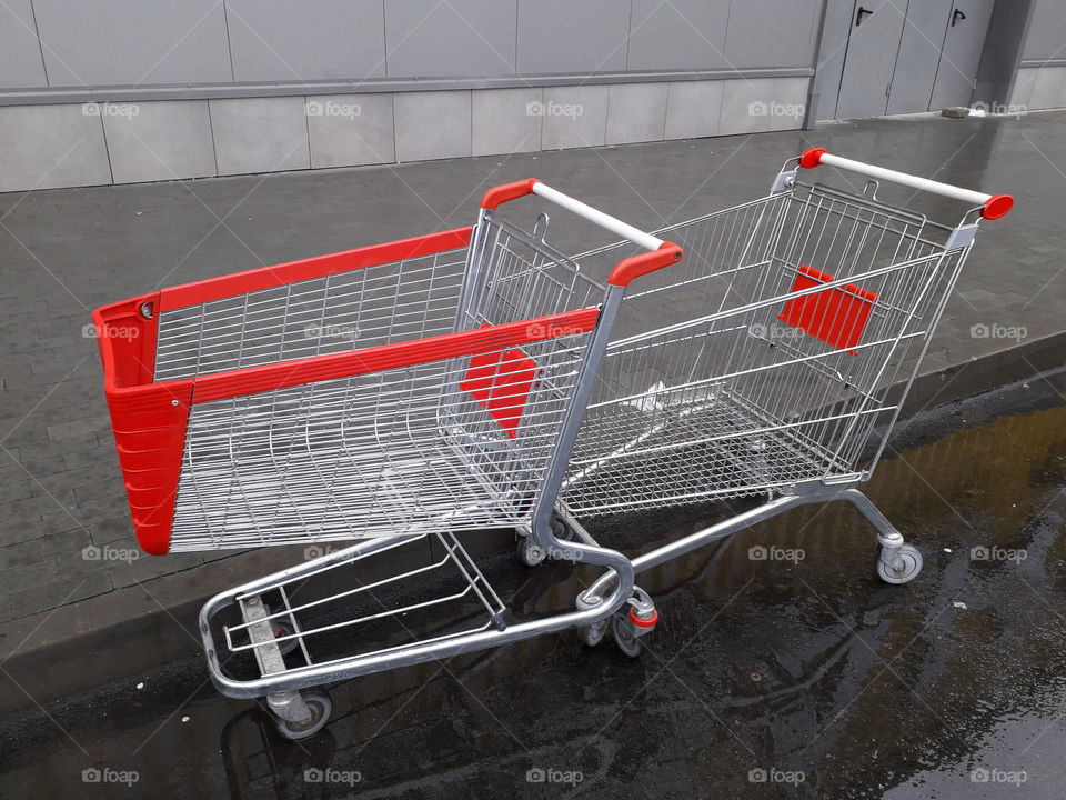 Carts for grocery products stand near a supermarket on the street