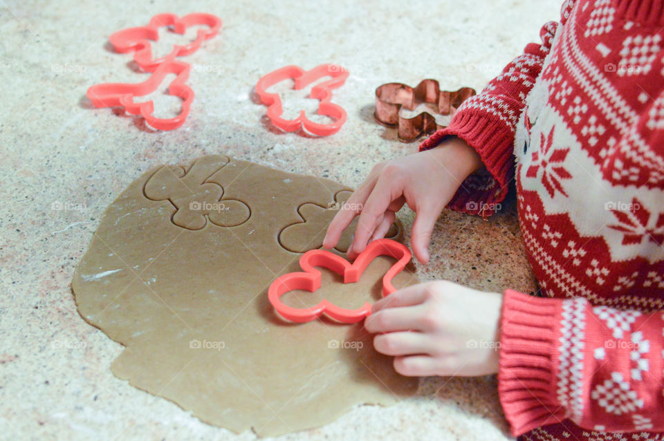 Child making Christmas cookies with a cookie cutter