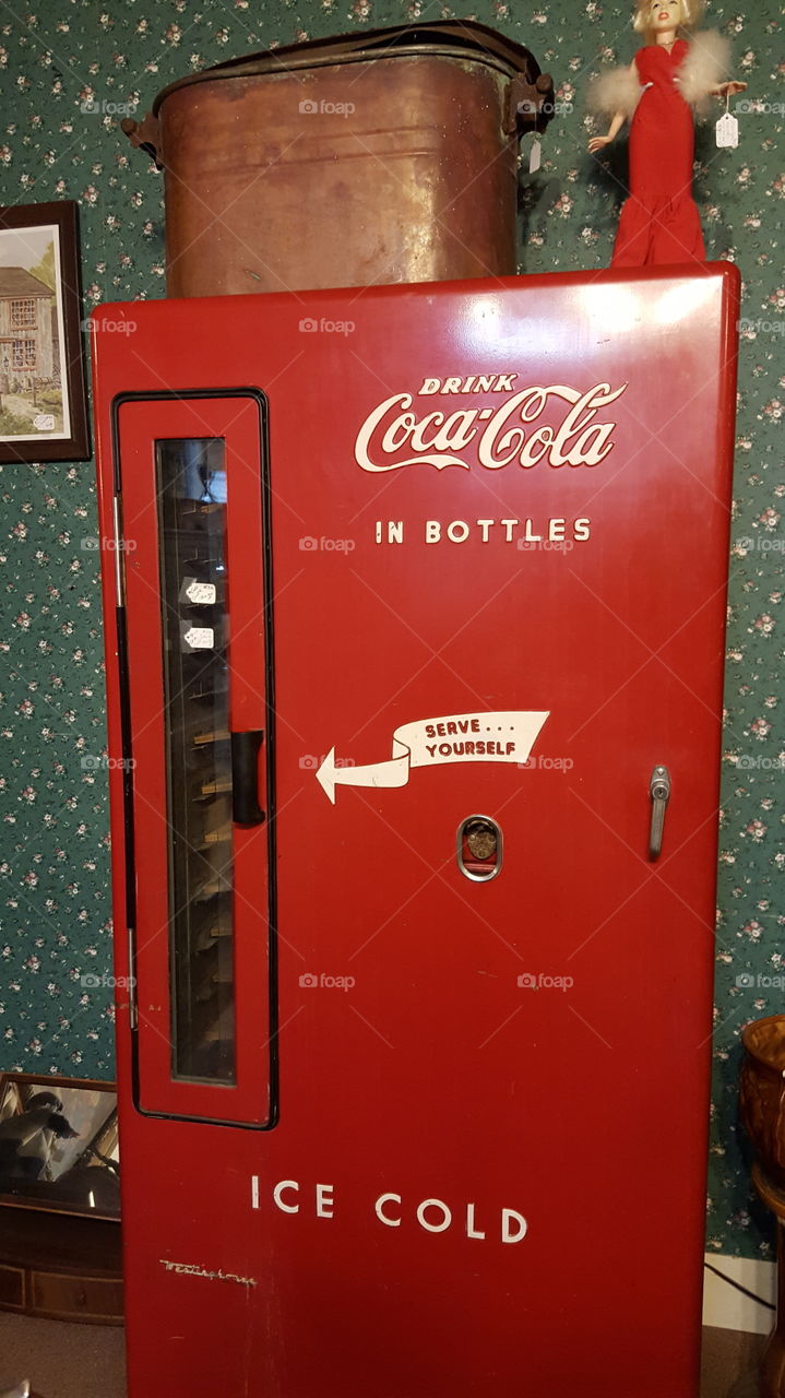 Coke for all. A self serve coke machine in an antique shop
