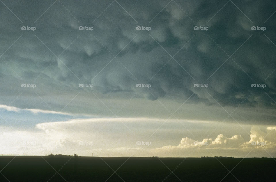 Mammatus clouds and thunderstorms in the distance over the Nebraska panhandle, photographed during a storm chase