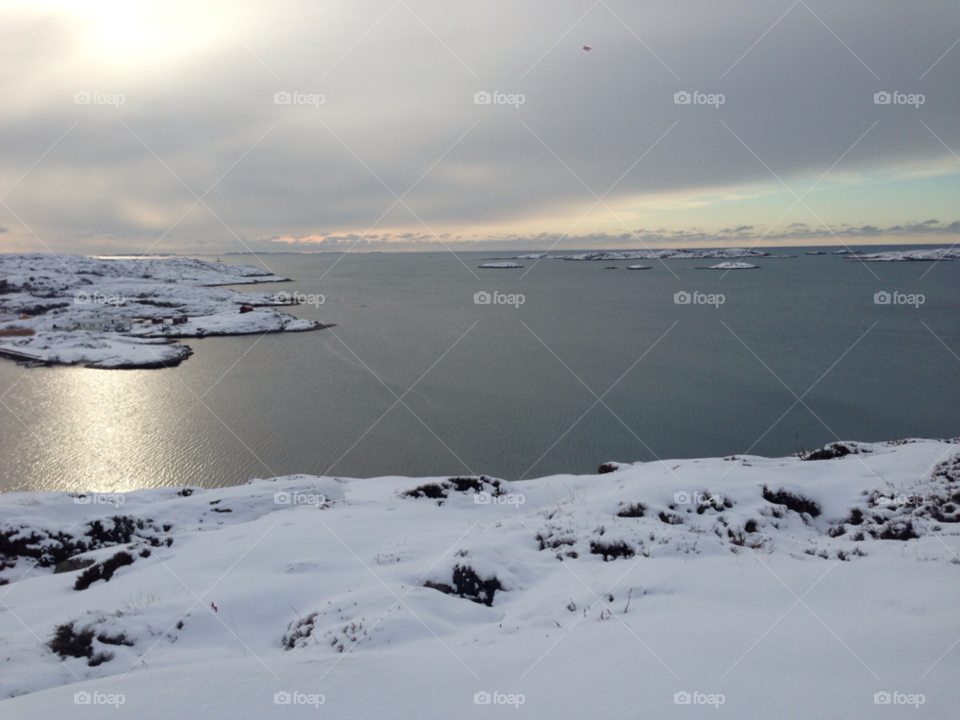 Winter landscape. Rocks with snow next to the sea. 