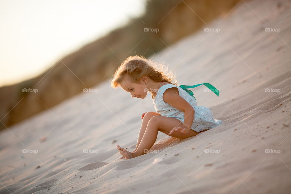 Little girl playing in the sand 