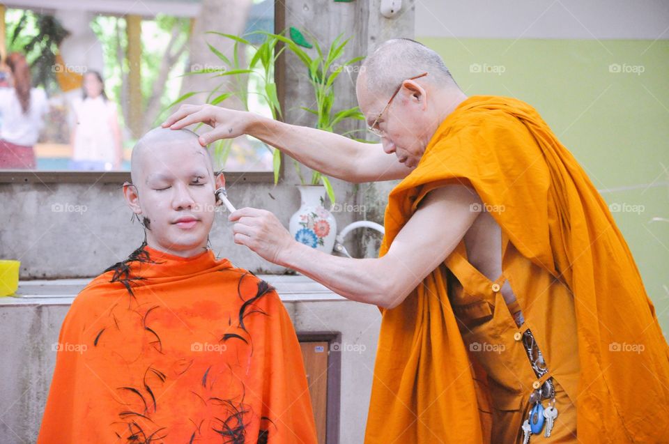 Ordinate. Monk is shaving his hair for ordination.