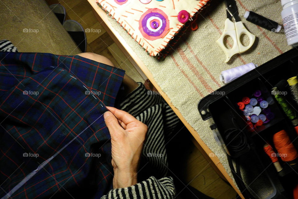 the girl sews a skirt in the autumn evening