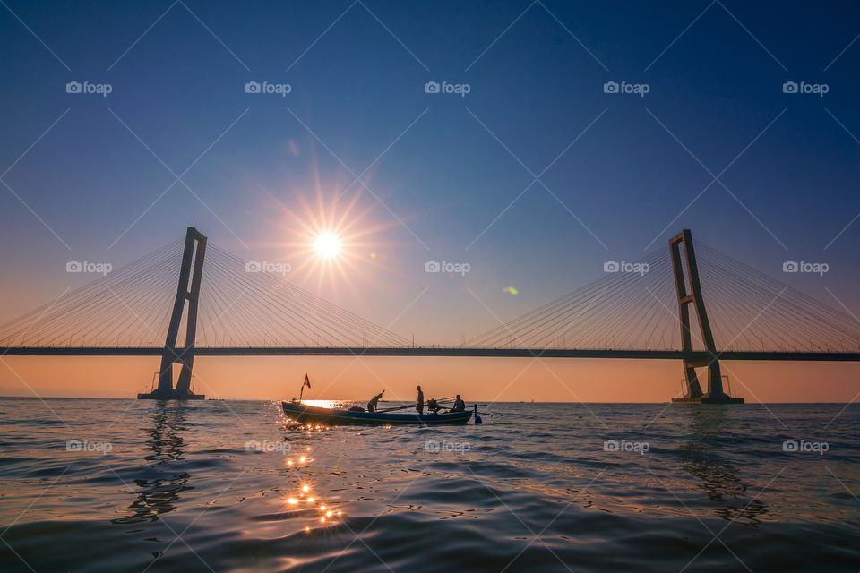 silhouette, fishermen and suramadu bridge in the morning