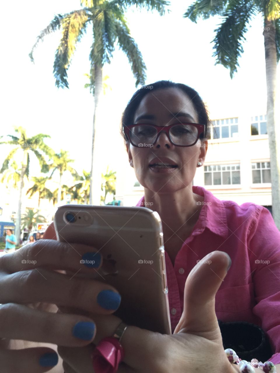 Text messaging. Woman sitting in an outdoor cafe using mobile phone, Florida 