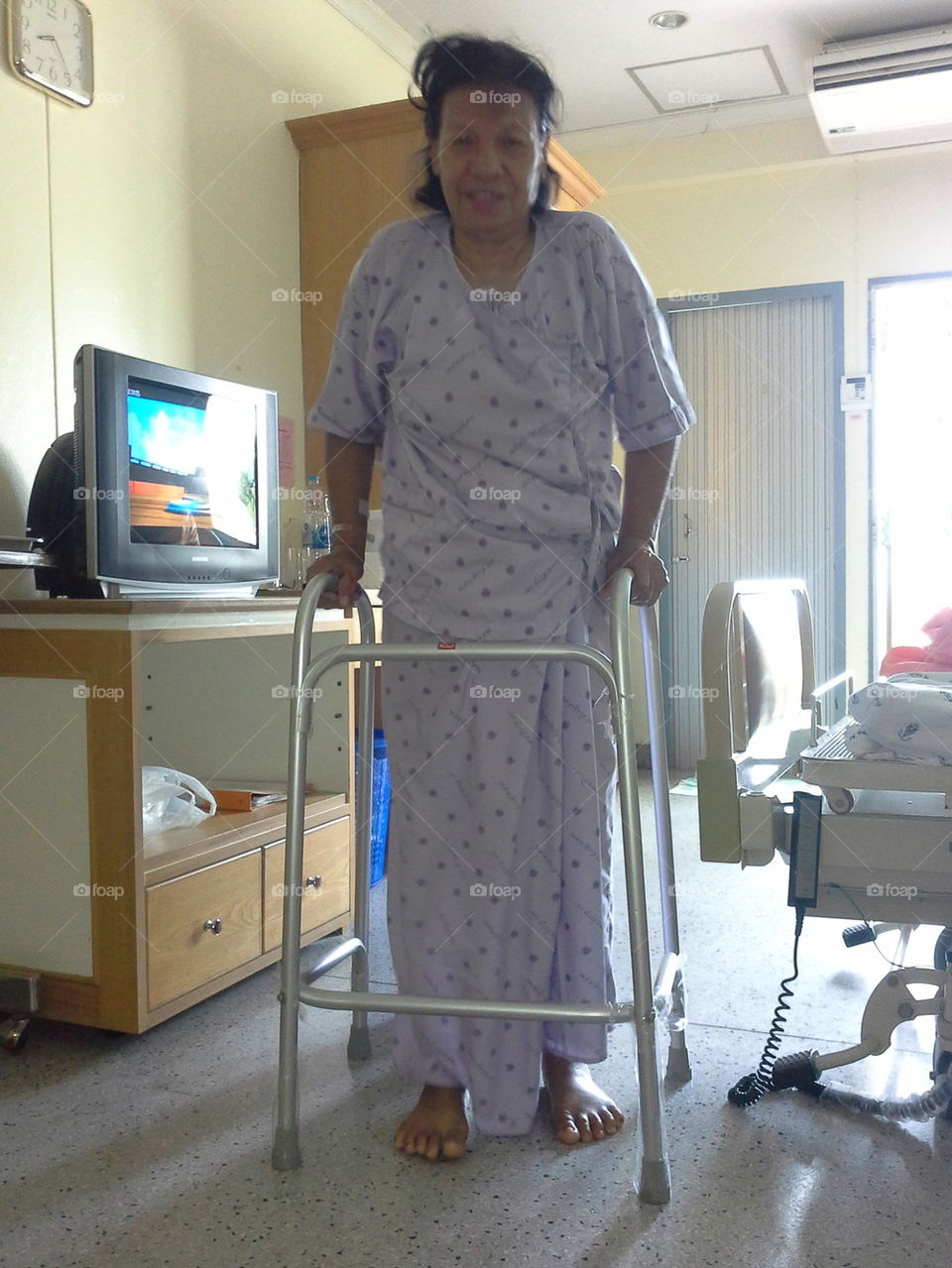 Senior Asian Thai female patient walk using walker