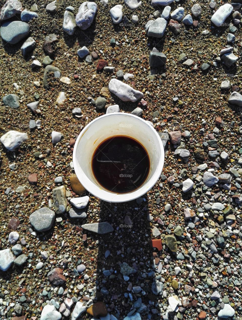 black coffee cup flat lay with beach background