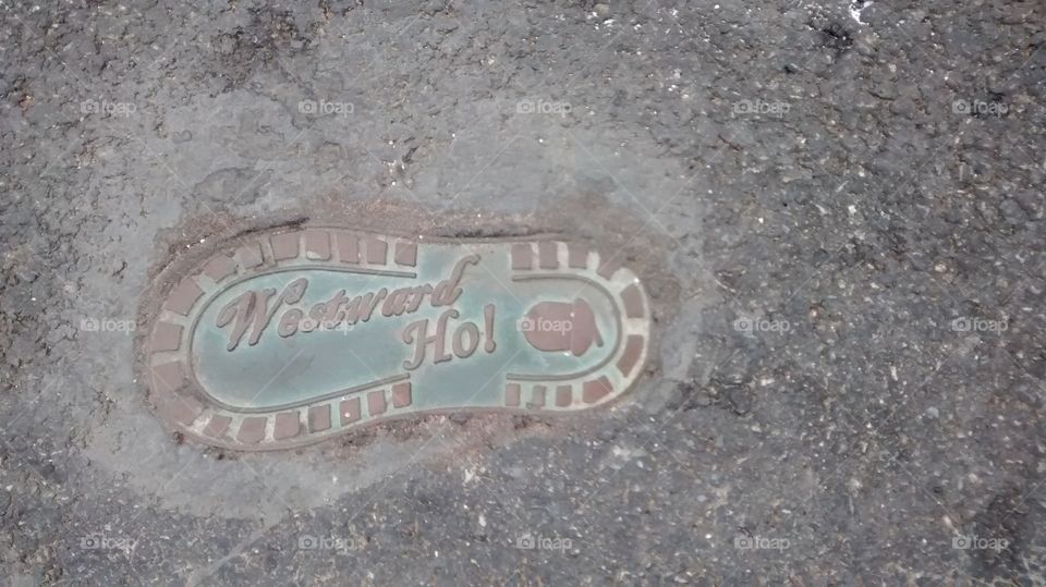 A metal footprint set into concrete in Westward Ho! - Britain's only (and one of 3 in the world) town with an exclamation point in it's name.