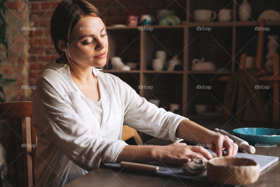Young woman girl crafting ceramic dishes in studio 