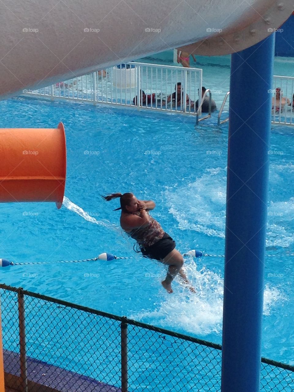 Long way down . Woman coming out of water slide at hurricane harbor