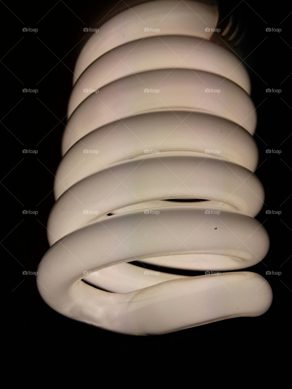 Spiral energy saving light lamp bulb on dark background