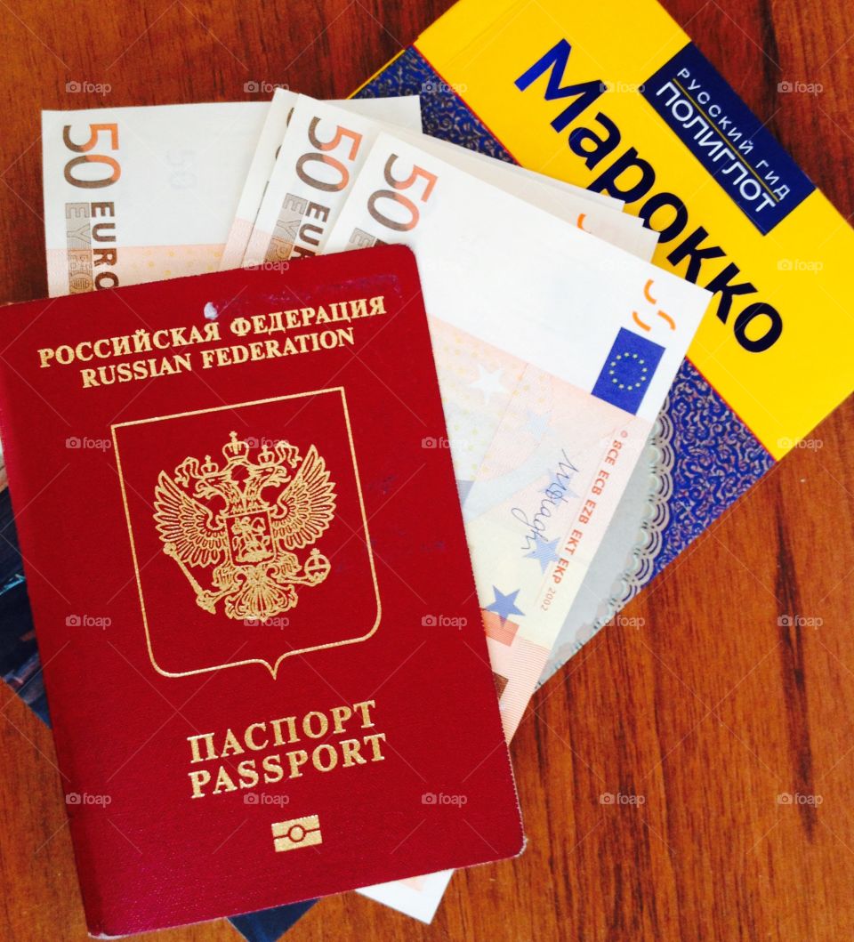 Start a travel . Photo of Russian passport, guide and euro money 
