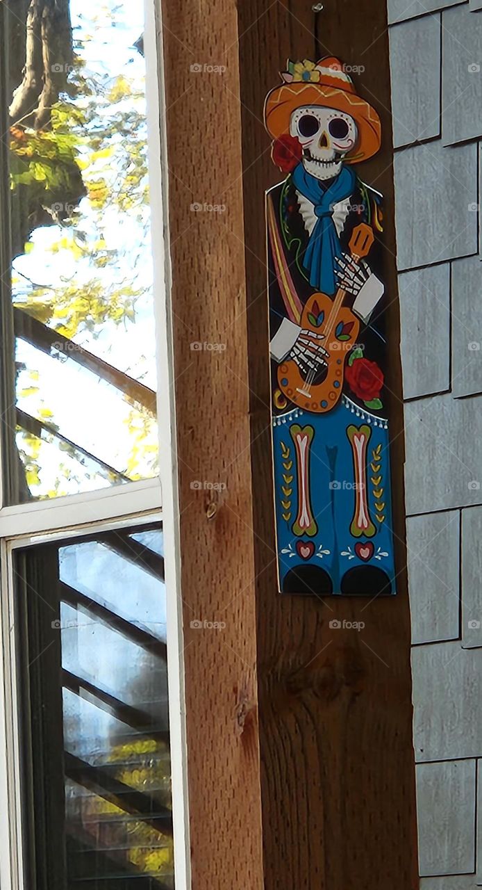 colorful Day of The Dead skeleton with guitar decoration on the outside of a home in Oregon