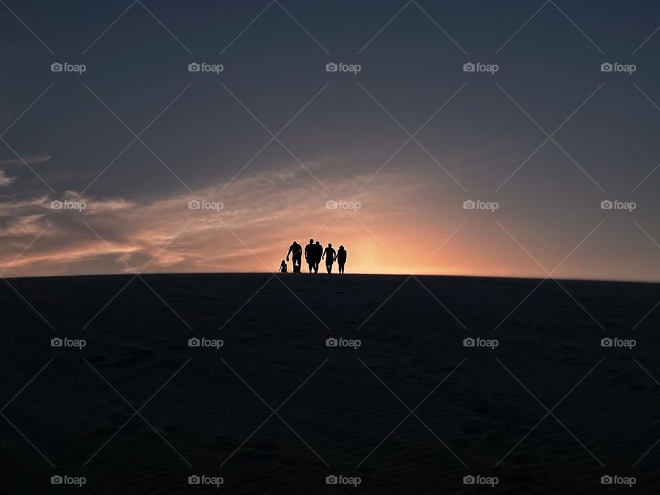 People walking on the dunes in the distance.