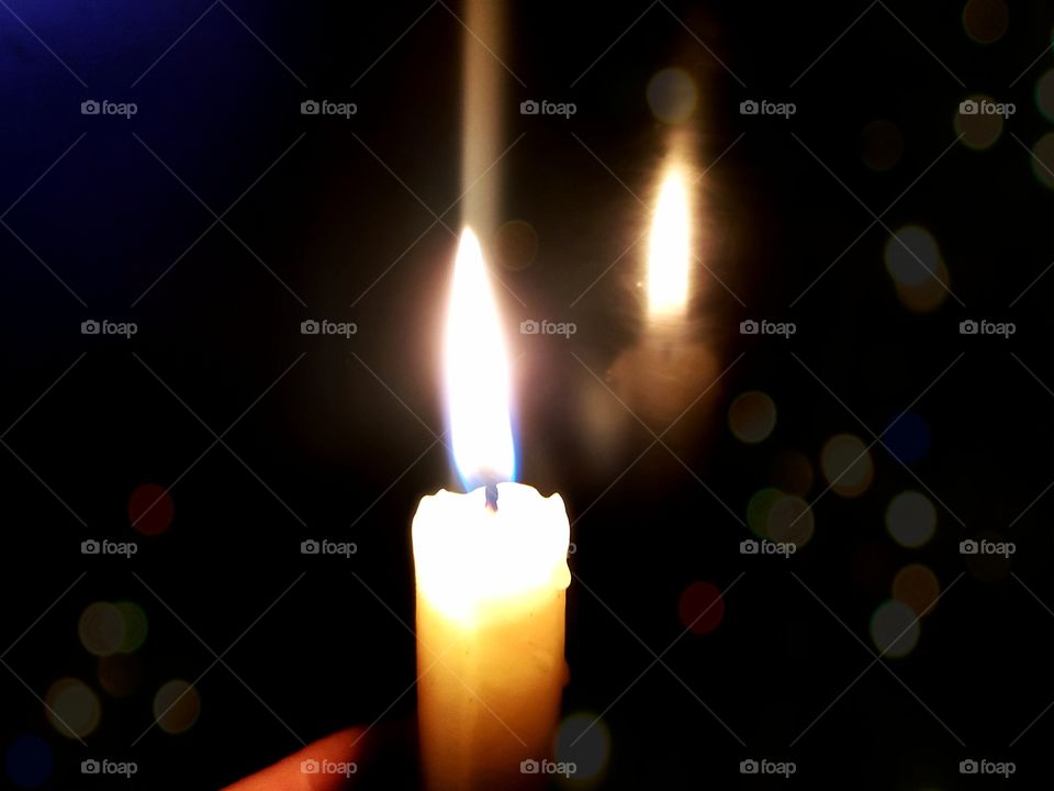 reflection of a burning candle on black glass
