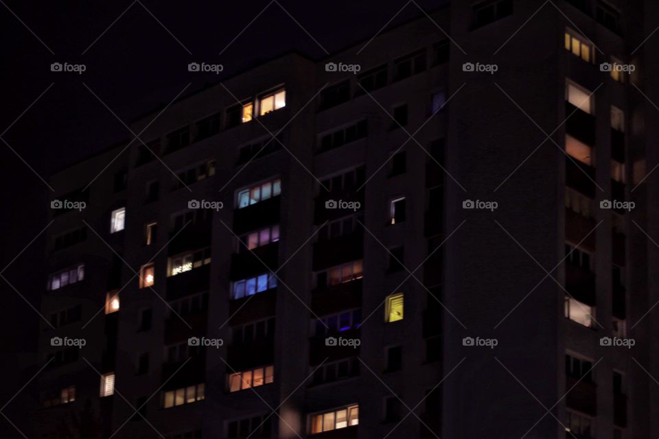 Night shot of a high-rise building with many colorful illuminated windows