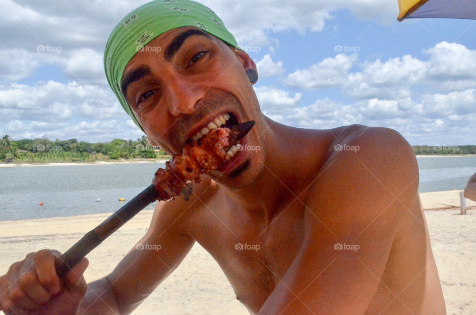 Man eating chicken skewer 