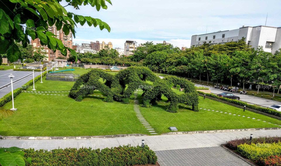 your local treasures: park surrounding The National Taiwan Museum of Fine Arts, show a abstract installation art composed of some different green live plants.