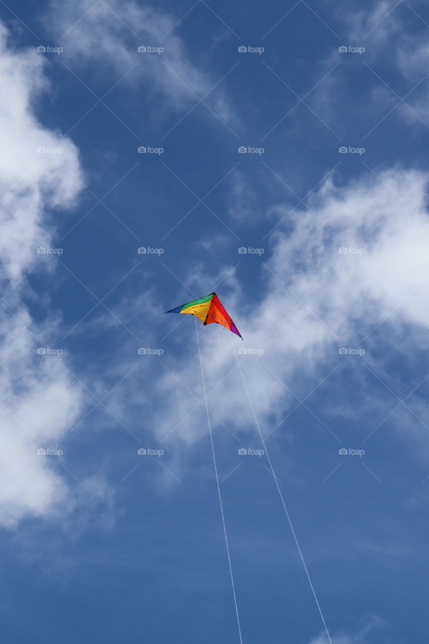 A kite in a blue sky with clouds