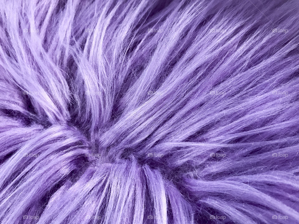 A plush texture of purple faux fur pillow