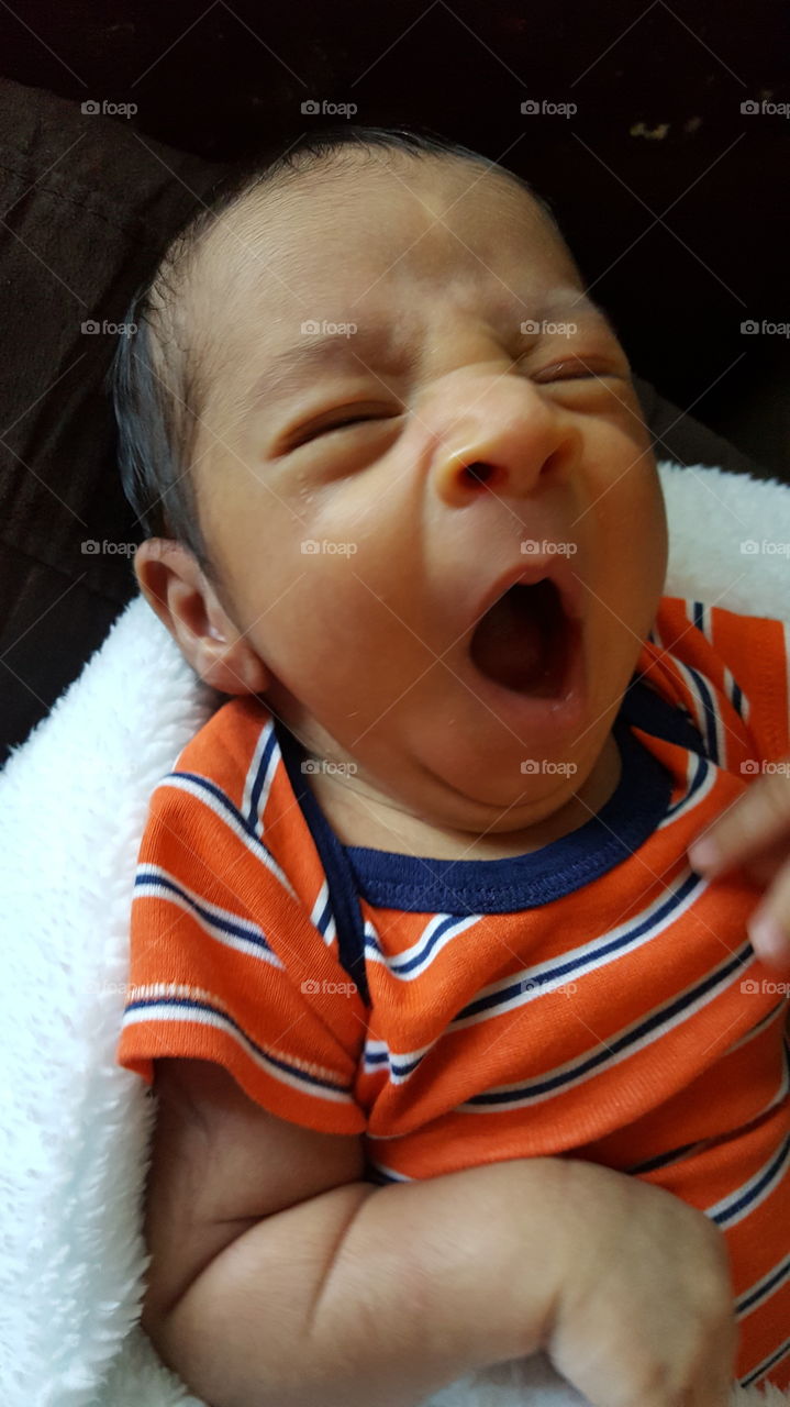 tired little baby boy yawning.
