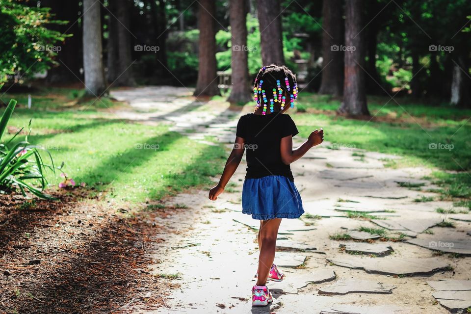 A little girl exploring the great out doors with curiosity.