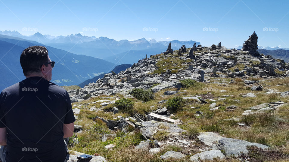 Hiking trail at high altitude. Hiker enjoying the panoramic view of mountains 