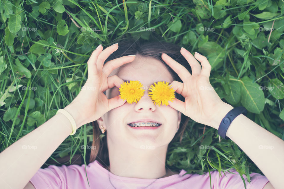 Portrait of happy girl with yellow flowers of dandelions.
