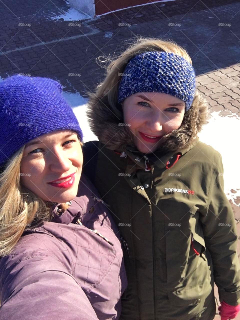 две девушки блондинки на улице в синих шапках
