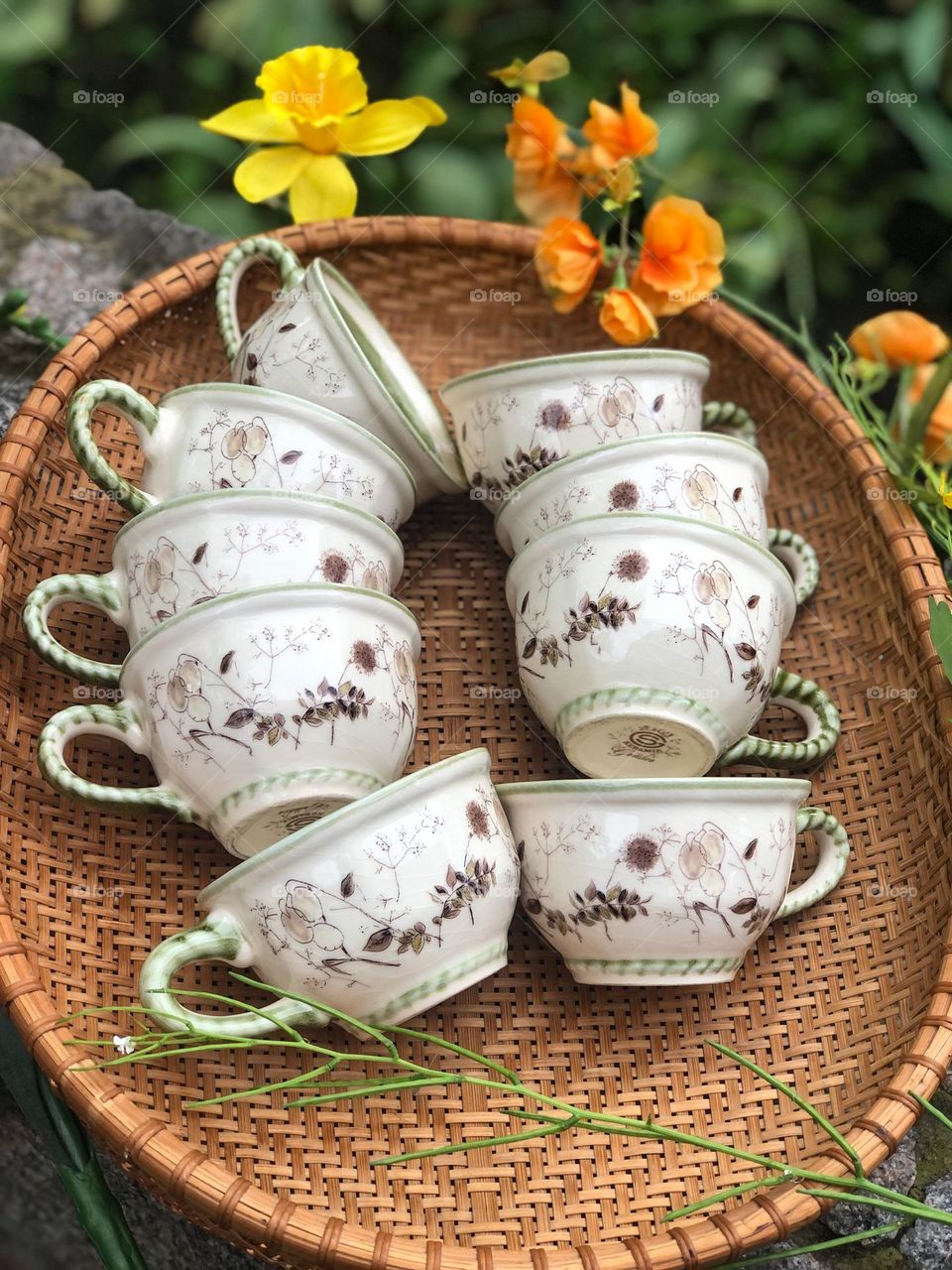 Old handmade pottery cups in soft green color and herbal pattern