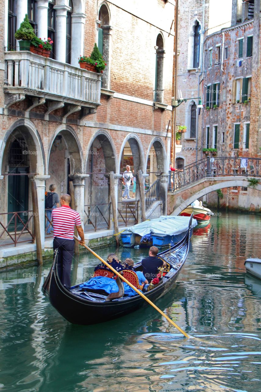Visitors to Venice cruise the canals in a gondola