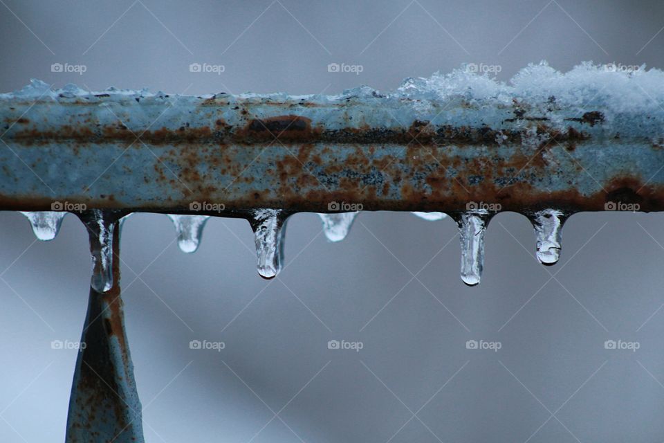 Mini icicles on a rusty railing
