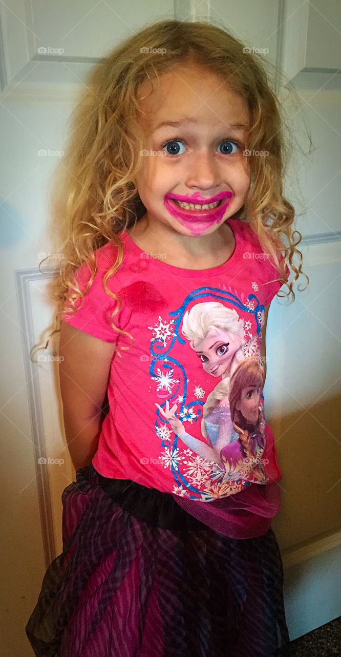 Portrait on little girl with messy lipstick