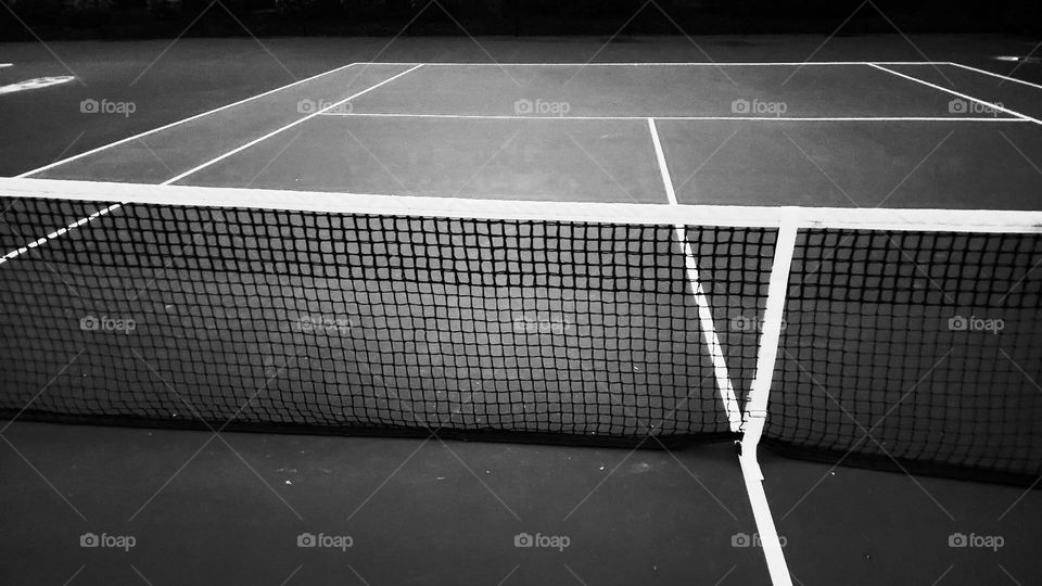 close up of the net on an empty outdoor Oregon tennis court in black and white