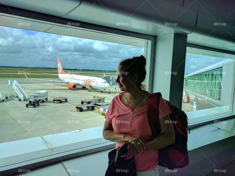 Happy and looking out of an Airport window