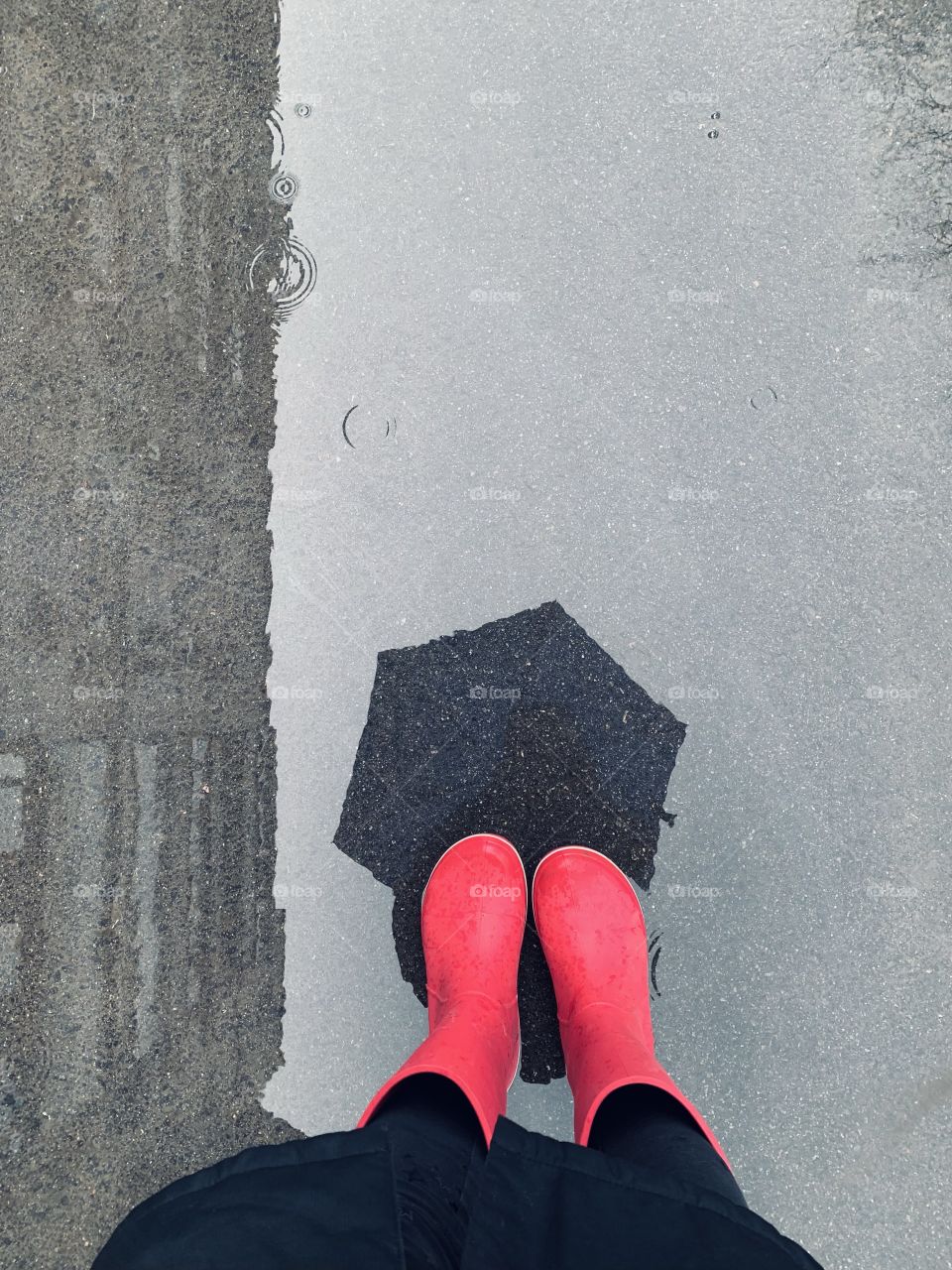 Woman in pink rain boots with umbrella shadow at paddle 