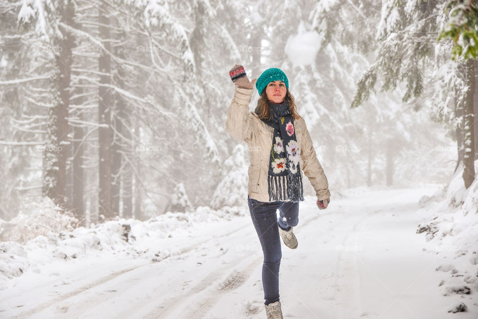 Woman running on road covered with snow