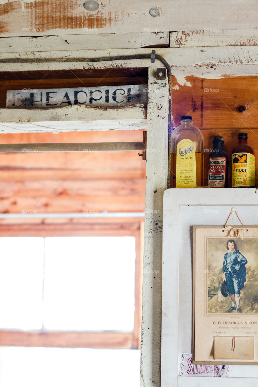 Vintage wood sign and old glass bottles on a shelf at the cottage
