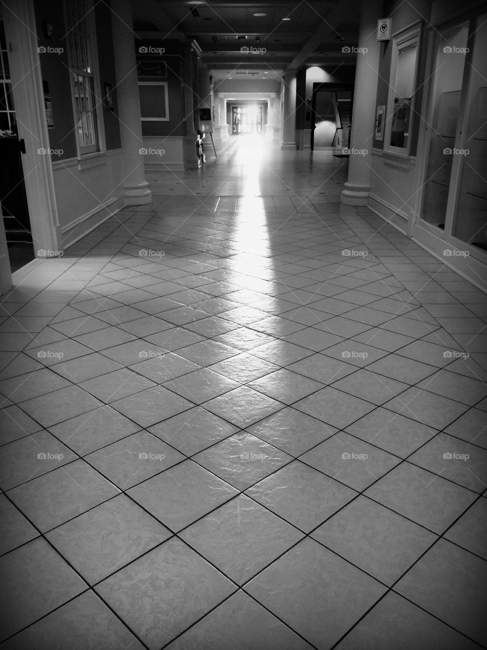 Light streaming through a doorway onto an empty dark hallway 