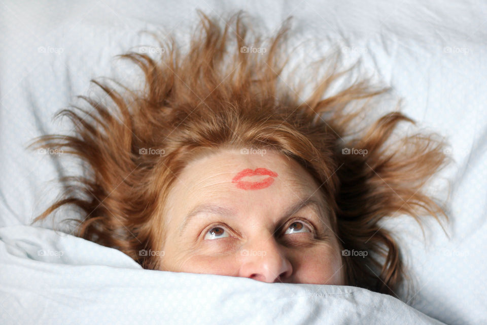 Red kiss on woman's head, redhead wiman in the bed