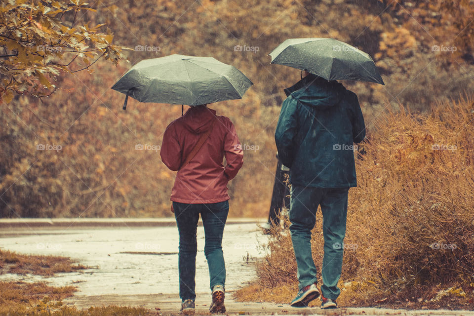 Couple with umbrellas walking in the rain