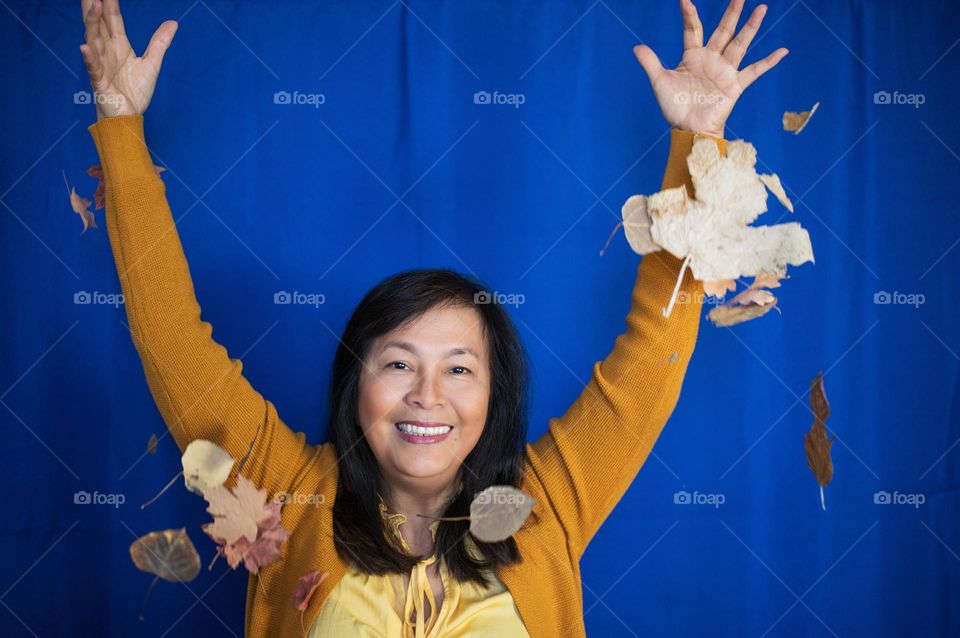 Woman enjoying falling leaves 