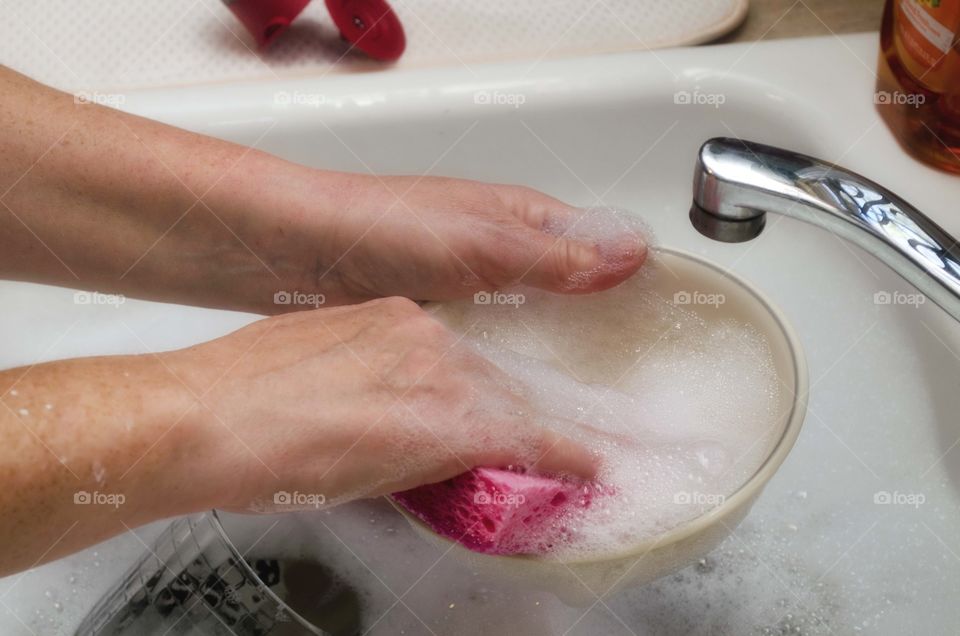 Close-up of woman's hand washing bowl
