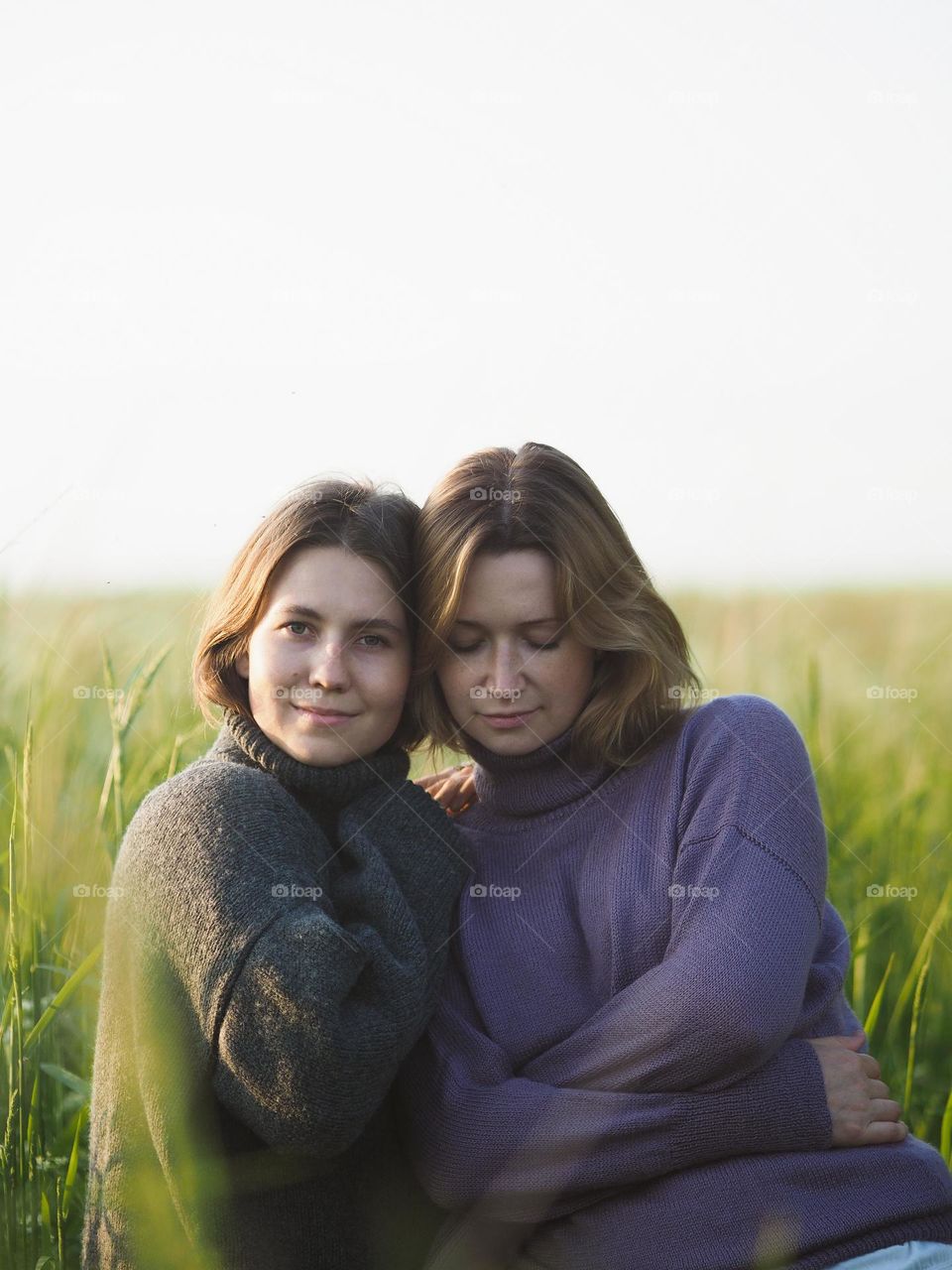 Two young beautiful woman’s standing in field in sunny summer day, portrait of woman 