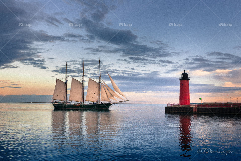 Big sailboat by red lighthouse in Milwaukee, Wi 
