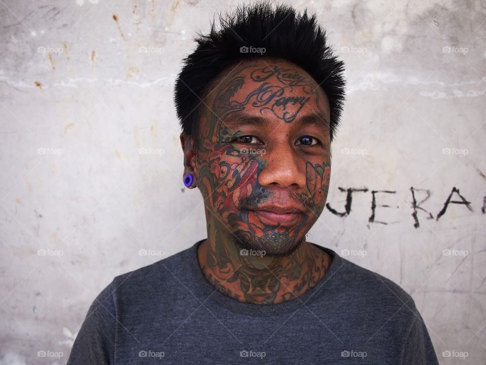 portrait of a man with facial tattoo