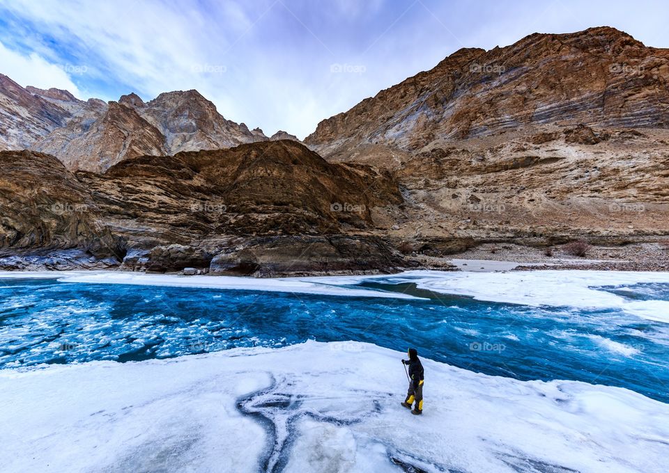 wanderlust trekker admiring the frozen lake of zanskar