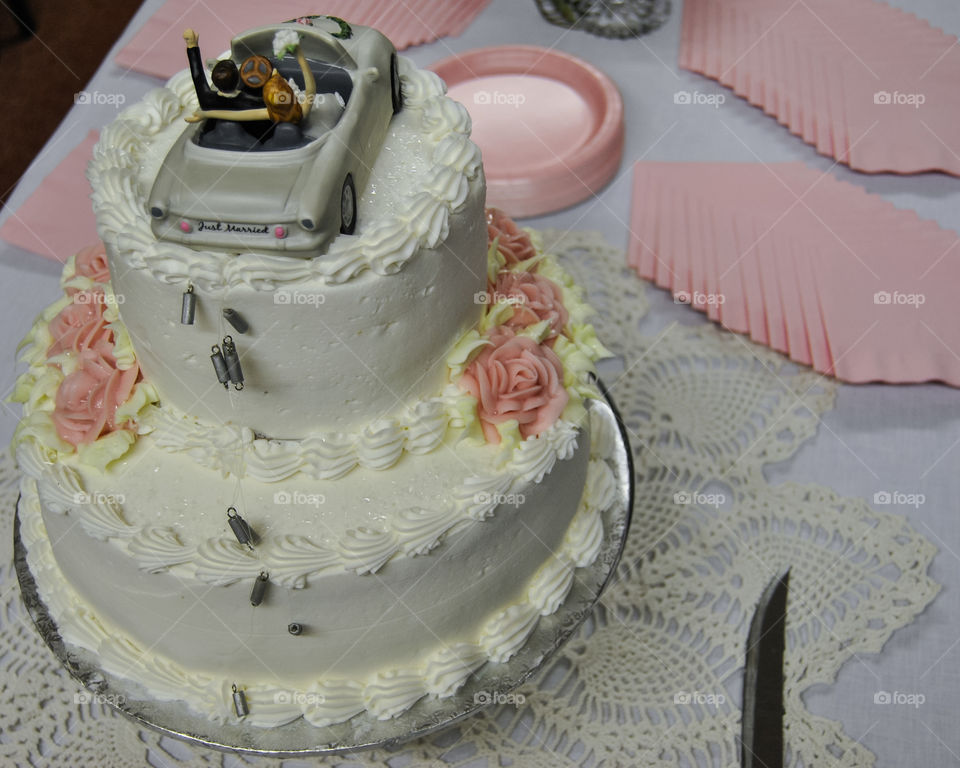 Cake that has tin cans and a car